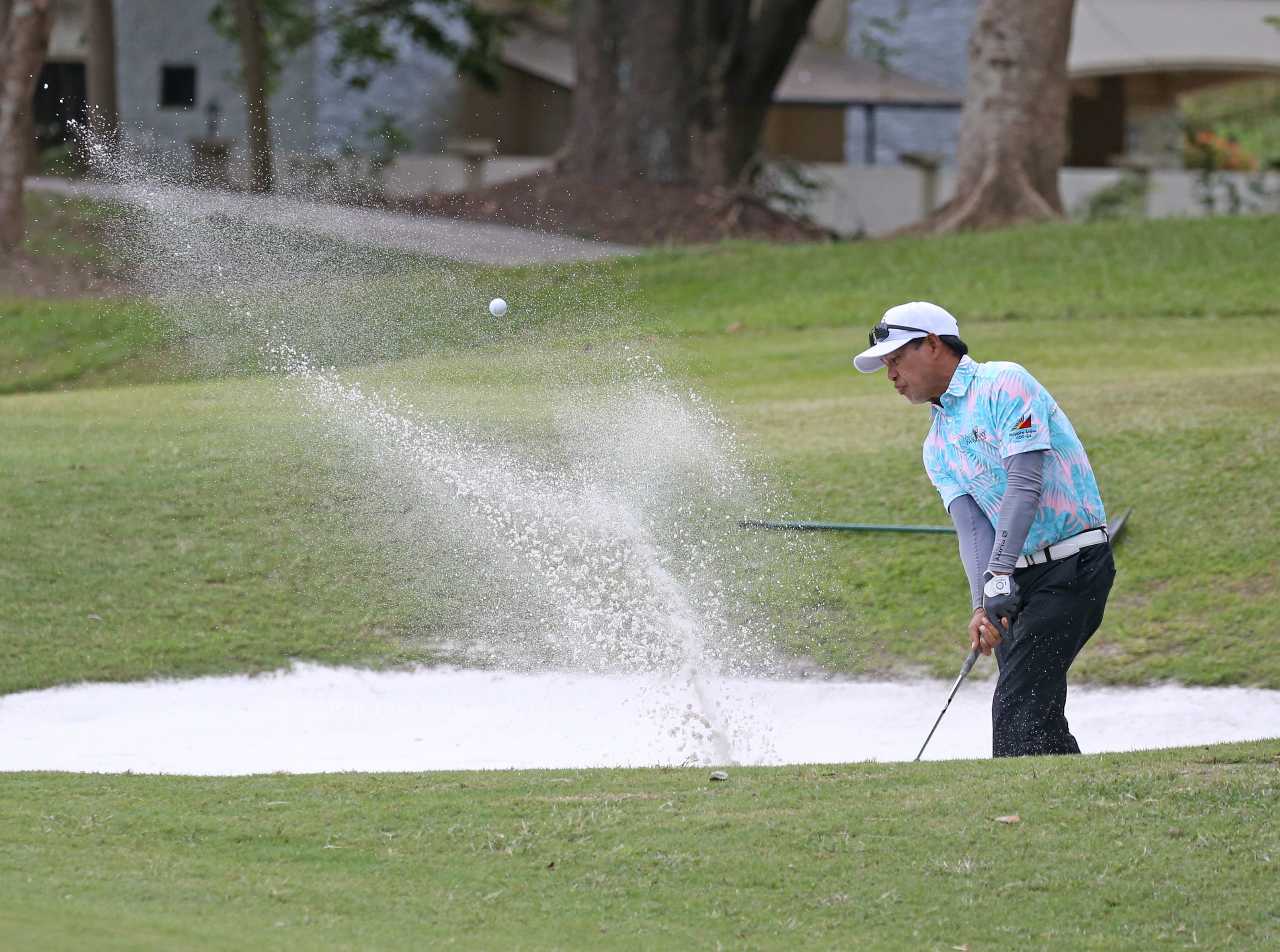 Ron Pagurayan of Fil-Am Fairway Hawaii blasts out of the bunker on the 18th hole at the Pueblo de Oro Golf and Country Club on the eve of the 75th PAL Men's Regular Interclub.